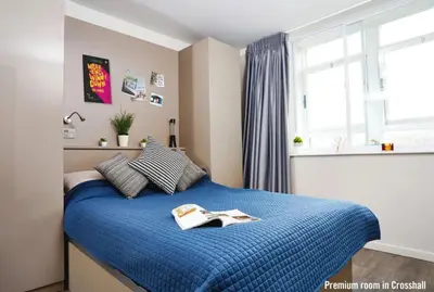 a bedroom with a blue bed with a book on it at For Students Only Cozy Stays at Crosshall Street in Liverpool