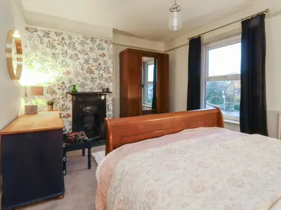 a bedroom with a bed and a desk and a fireplace at Levenside in Preston
