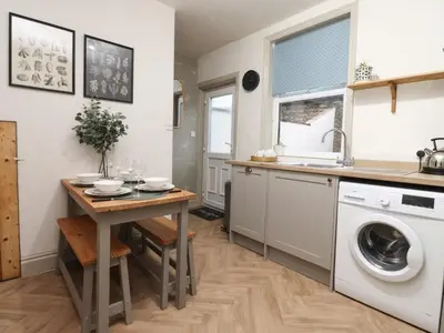 a kitchen with a table and a washing machine at Levenside in Preston
