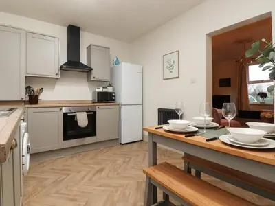 a kitchen with a table and a kitchen with white appliances at Levenside in Preston