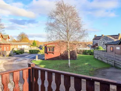 a brick house with a tree in the yard at Kingfisher Lodge - Arnside 14 in Carnforth
