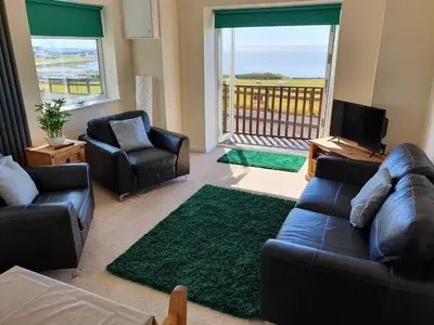 a living room with a couch and chairs and a television at Retreat By The Seaside in Heysham