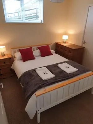 a bedroom with a large bed with two towels on it at Retreat By The Seaside in Heysham