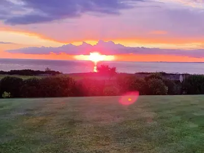 a sunset over the ocean with a frisbee in a field at Retreat By The Seaside in Heysham