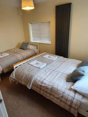 a bedroom with two beds with towels on them at Retreat By The Seaside in Heysham