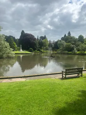 a park bench sitting in front of a lake at Grayrigge Croft Cottage in Grange Over Sands
