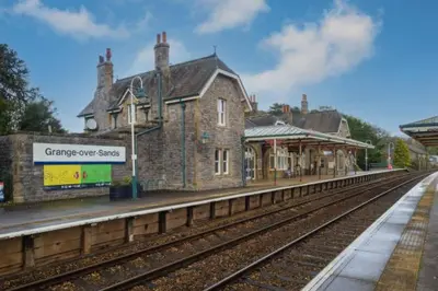 an old train station with a train track and a building at Grayrigge Croft Cottage in Grange Over Sands