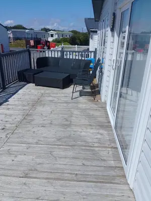 a deck with a couch and chairs on a house at Happy Go Lucky Lodge in Middleton