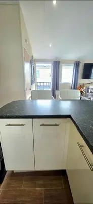 a kitchen with white cabinets and a black counter top at Happy Go Lucky Lodge in Middleton