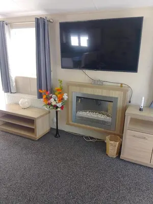 a living room with a fireplace with a tv above it at Happy Go Lucky Lodge in Middleton