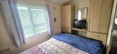 a bedroom with a bed and a window and a tv at Happy Go Lucky Lodge in Middleton