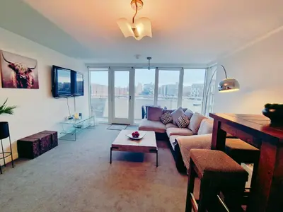 a living room with a couch and a tv at 5 star Luxury Apartment in City Centre with views in Liverpool