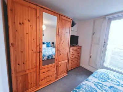 a bedroom with a large wooden cabinet and a bed at 5 star Luxury Apartment in City Centre with views in Liverpool