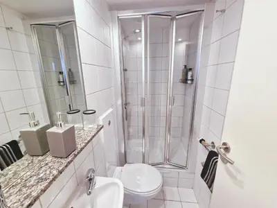 a white bathroom with a shower and a toilet at 5 star Luxury Apartment in City Centre with views in Liverpool