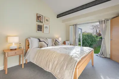 a bedroom with a large bed and a window at Royal Oak Barn - Cartmel, Sleeps 8 NEW in Cartmel