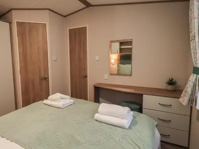 a bedroom with a bed with two towels on it at Foxwood Hideaway in Carnforth
