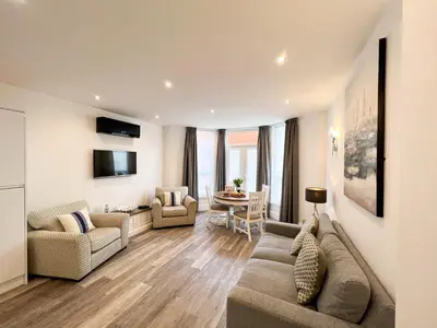 a living room with a couch and a table at St Annes Beach Apartments in Lytham St Annes