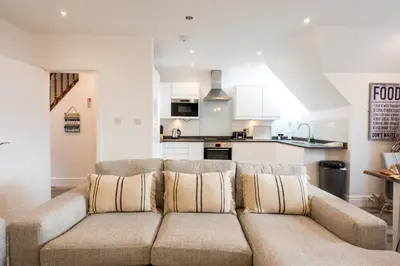 a living room with a couch and a kitchen at St Annes Beach Apartments in Lytham St Annes