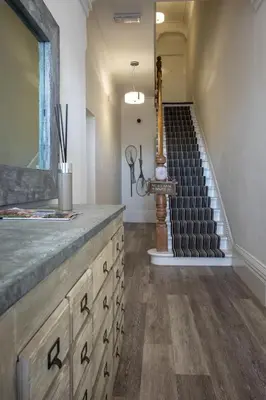 a room with a wooden dresser and a staircase at St Annes Beach Apartments in Lytham St Annes