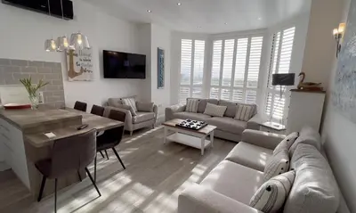 a living room with a couch and a table at St Annes Beach Apartments in Lytham St Annes