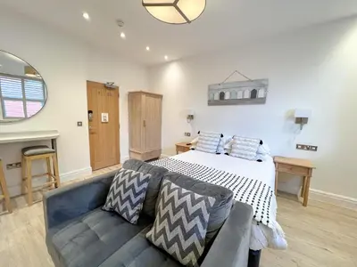 a large bedroom with a bed and a couch at St Annes Beach Apartments in Lytham St Annes