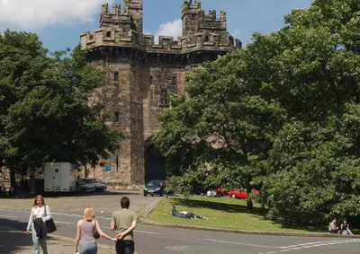 a group of people walking in front of a castle at Gemini in Heysham