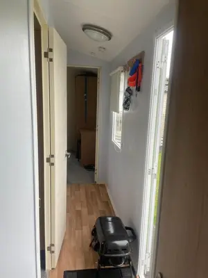 a room with a hallway with a suitcase on the floor at Gemini in Heysham