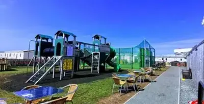 a playground with a slide and tables and chairs at Gemini in Heysham