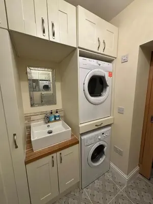a small bathroom with a sink and a washing machine at Entire House, Parking, Facilities, sleeps up to 6, suitable for contractors, families or NHS in Liverpool