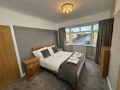 a bedroom with a large bed and a window at Entire House, Parking, Facilities, sleeps up to 6, suitable for contractors, families or NHS in Liverpool