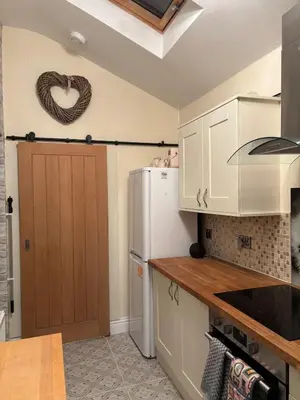 a kitchen with a white refrigerator and a heart sign on the wall at Entire House, Parking, Facilities, sleeps up to 6, suitable for contractors, families or NHS in Liverpool