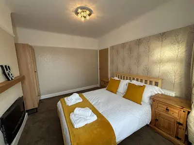 a bedroom with a large bed with towels on it at Entire House, Parking, Facilities, sleeps up to 6, suitable for contractors, families or NHS in Liverpool