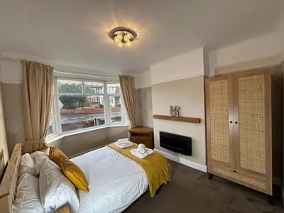 a bedroom with a large bed and a window at Entire House, Parking, Facilities, sleeps up to 6, suitable for contractors, families or NHS in Liverpool
