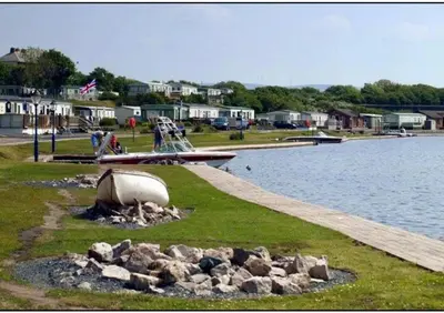 a playground next to a body of water with rocks at The Bluebell in Haverigg
