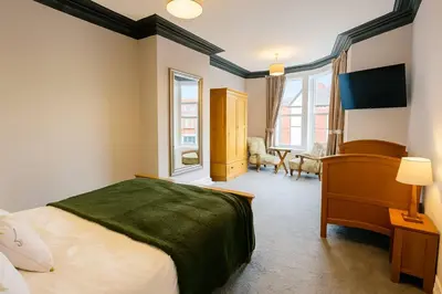 a bedroom with a bed and two windows at Large 6 Bed Southport Coastal Retreat with Sauna in Southport