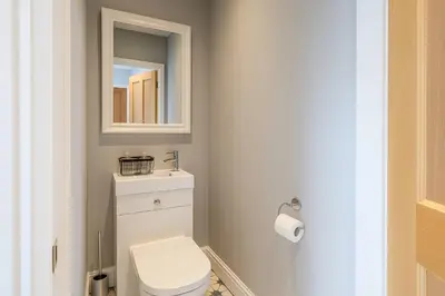 a bathroom with a white toilet and a mirror at Large 6 Bed Southport Coastal Retreat with Sauna in Southport