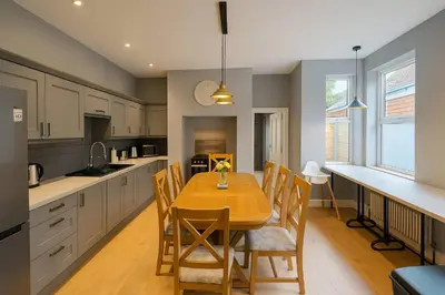 a kitchen with a wooden table and chairs in it at Large 6 Bed Southport Coastal Retreat with Sauna in Southport