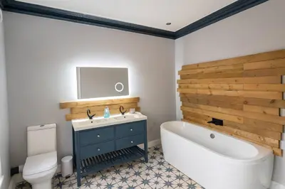 a bathroom with a tub and a sink and a toilet at Large 6 Bed Southport Coastal Retreat with Sauna in Southport