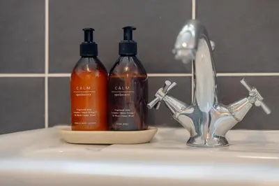 two bottles of soap sitting on a bathroom sink at Moorland Bungalow Central Clitheroe in Clitheroe