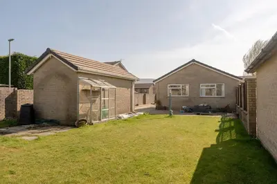 a backyard of a house with a grass yard at Moorland Bungalow Central Clitheroe in Clitheroe