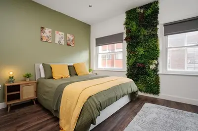 a bedroom with a bed with a green wall at L1 City Centre Stay! Nightlife, Close to everything! Carpark on street! in Liverpool