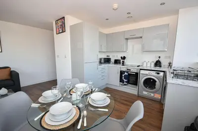 a kitchen and dining room with a glass table and chairs at Modern 1BED Flat in Central Liverpool - City Views in Liverpool