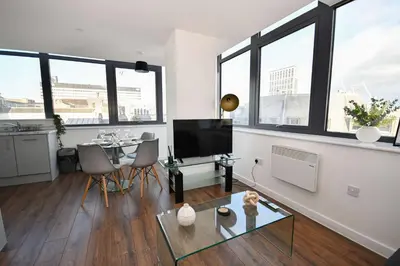 a living room with a table and some windows at Modern 1BED Flat in Central Liverpool - City Views in Liverpool