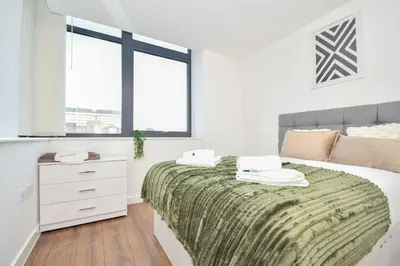 a bedroom with a bed and a dresser and two windows at Modern 1BED Flat in Central Liverpool - City Views in Liverpool