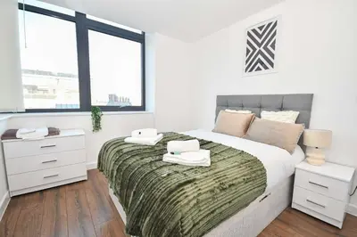 a white bedroom with a large bed and windows at Modern 1BED Flat in Central Liverpool - City Views in Liverpool