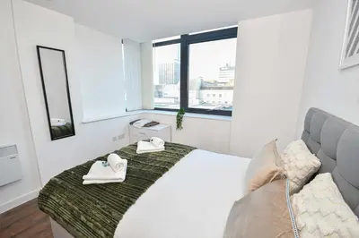 a white bedroom with a bed with towels on it at Modern 1BED Flat in Central Liverpool - City Views in Liverpool