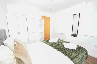 a white bedroom with a bed with a green blanket at Modern 1BED Flat in Central Liverpool - City Views in Liverpool
