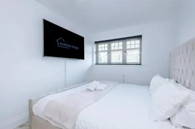 a white bedroom with a bed and a tv on the wall at Driveway Stunning 3Bedroom Home in Preston in Broughton