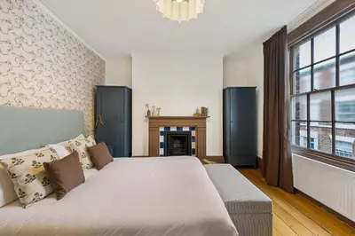 a bedroom with a large bed and a fireplace at Liverpool Georgian Townhouse for Family & Groups in Liverpool
