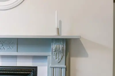 a fireplace in a room with a clock on the wall at Liverpool Georgian Townhouse for Family & Groups in Liverpool
